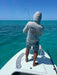 Angler standing on a flats skiff boat deck casting a fly line managed cleanly by the Scientific Anglers Launch Pad mat