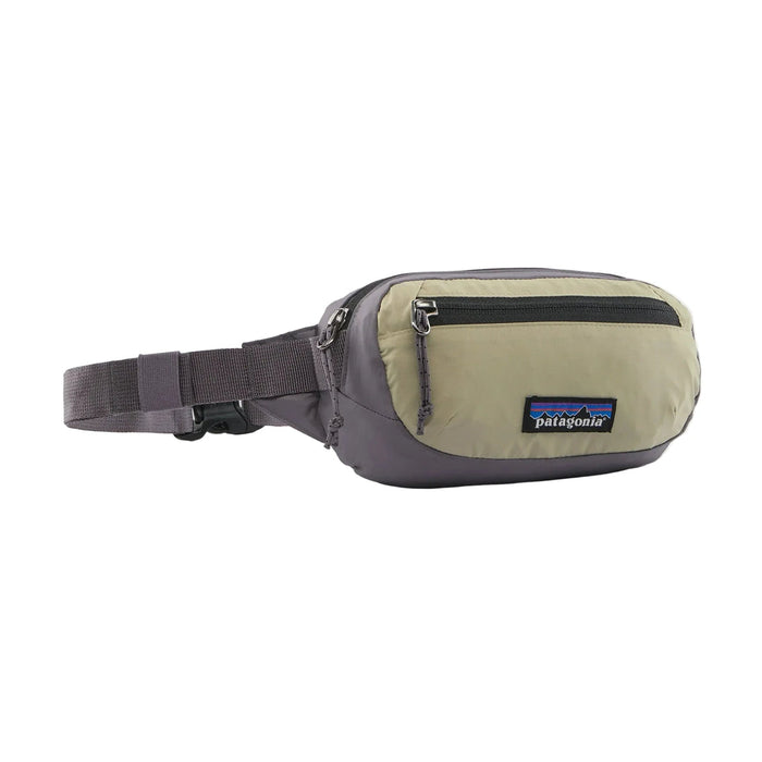 A Patagonia waist bag in a light khaki-beige and dark gray colorway, featuring a front zippered pocket and an adjustable webbing strap, shown against a plain white background.