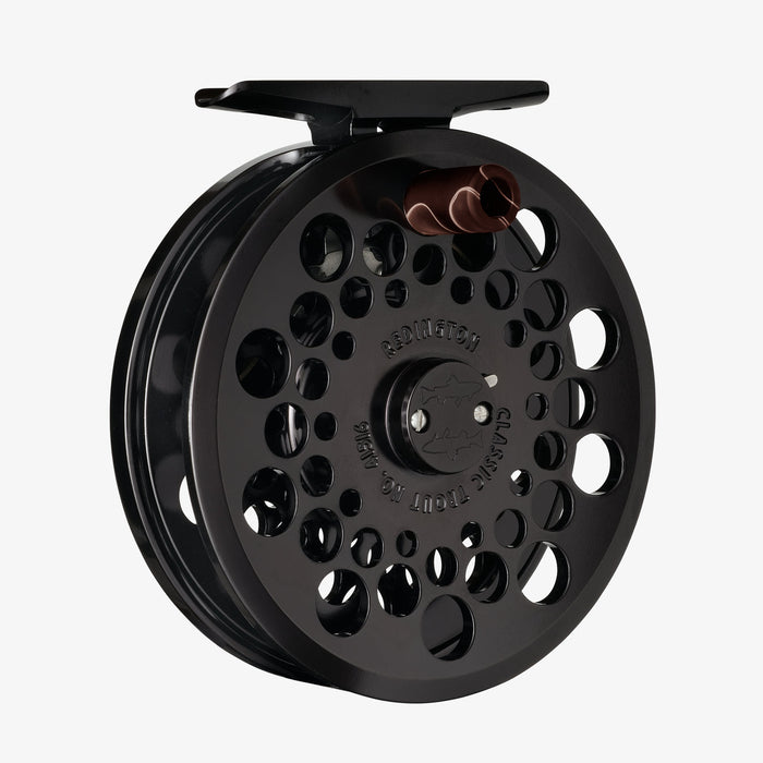 Black fly fishing reel on a white background