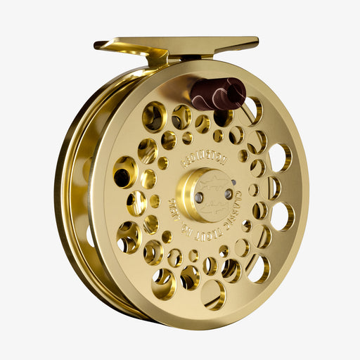 Gold fly fishing reel on a white background