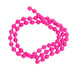 A strand of bright pink plastic beads connected by thin pink cords, coiled in a circle on a plain white background.