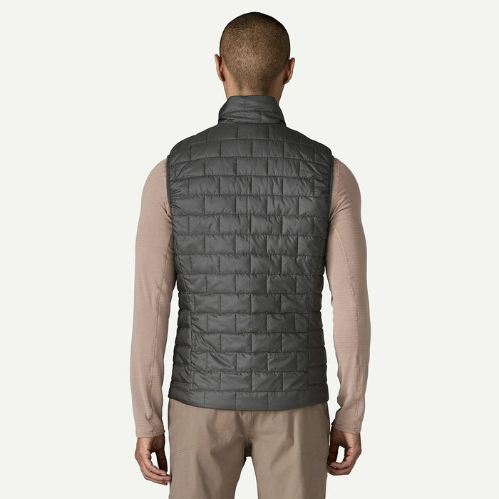Back profile of a man wearing the Forge Grey Patagonia Nano Puff Vest highlighting the drop-tail hem and clean athletic fit