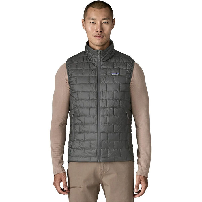 Front view of a man wearing the Forge Grey Patagonia Nano Puff Vest showcasing its low-profile lightweight fit