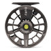 A close-up studio shot of a fly fishing reel spool, featuring a dark metallic gray body with cutout spokes, the brand name 'GURU' printed vertically on the top arm, and 'LAMSON' on the lower arm, with a small yellow-green center button.