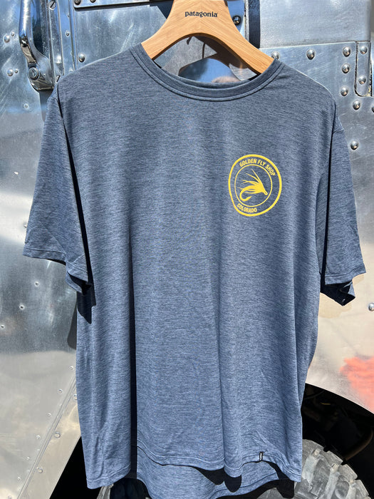 Smolder Blue Patagonia Capilene Cool Daily Tech Tee hanging up, showing the subtle gold left chest shop logo.