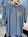 Smolder Blue Patagonia Capilene Cool Daily Tech Tee hanging up, showing the subtle gold left chest shop logo.