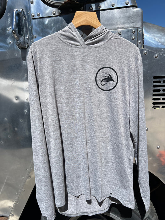 Feather Grey Patagonia Capilene Cool Daily Hoody hanging up, featuring the clean black circular trout fly logo on the left chest.