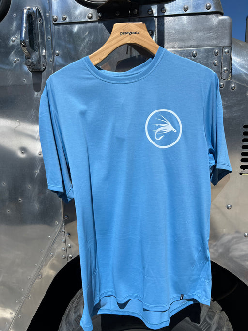 Shore Blue Patagonia Capilene Cool Daily Shirt showcasing the clean white circular trout fly logo on the left chest.