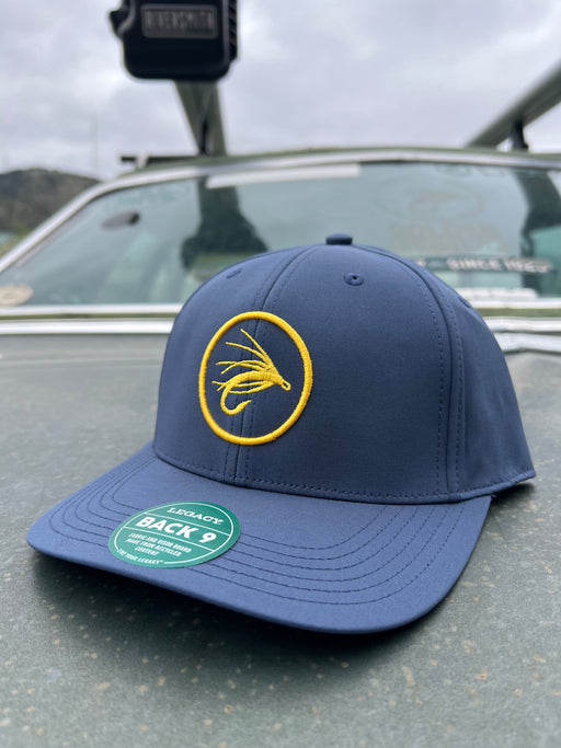 Golden Fly Shop Back Nine Hat Sea Blue 2026 edition structured performance cap made from recycled materials featuring a circular gold embroidered fly silhouette patch