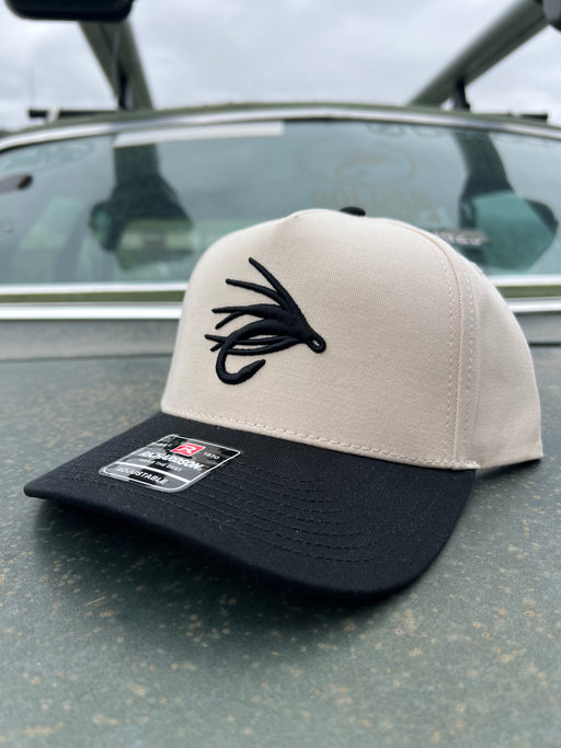 Golden Fly Shop Simple Logo Hat Cream Black 2026 edition structured Richardson snapback cap featuring a large black embroidered fly silhouette logo
