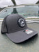 Grey variant of the Golden Fly Shop 112 Trucker Hat 2026 displaying a solid dark grey structured front crown, matching grey mesh backing, and circular rubber fly logo patch