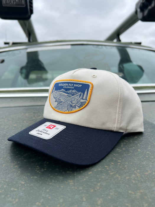 Golden Fly Shop Hat Underwood Cream Navy 2026 edition displaying a custom embroidered trout illustration patch on a Richardson structured mid profile frame