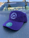 Purple variant of the Golden Fly Shop Dad Hat 2026 resting on a car hood showcasing the unstructured cotton crown and circular embroidered fly logo patch