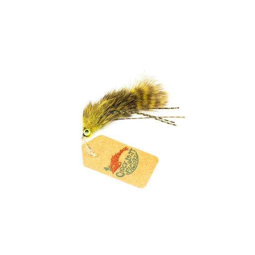 Side profile view of Chocklett's Bugger Game Changer fly in Olive, showing its multi-jointed articulated body segments, barred rubber legs, and a Chocklett Factory card tag.