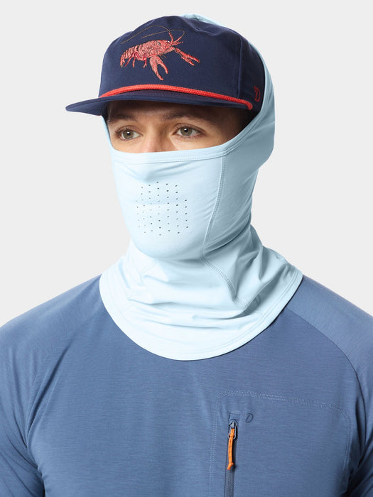 Angler wearing the Ice Water blue Camp Brrr Rockport Gaiter sun mask pulled up with a technical fishing hat.