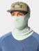 Angler wearing the Seafoam green Duck Camp Brrr Rockport Gaiter sun mask pulled up with a technical fishing hat.