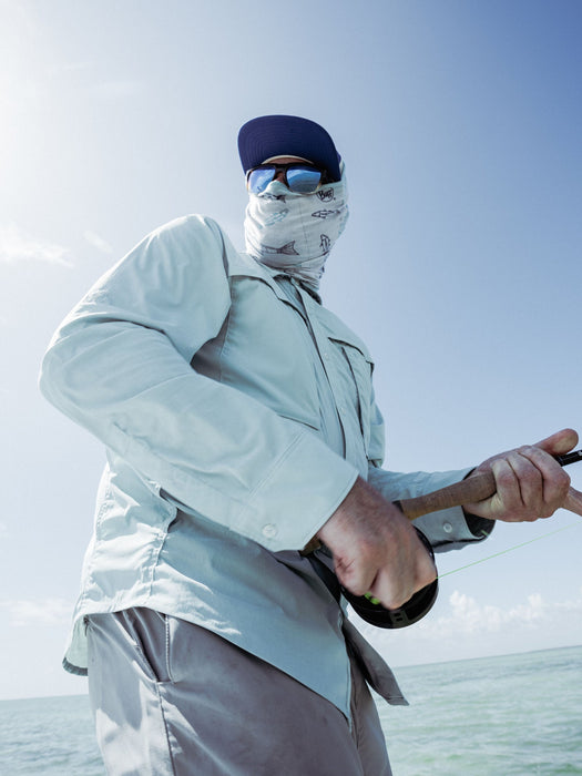 Angler wearing the Duck Camp lightweight fishing shirt while casting from a flats boat deck in hot weather.