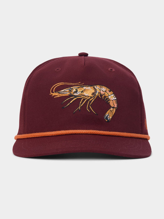 A maroon structured baseball cap featuring an embroidered orange and yellow prawn on the front, with a contrasting orange rope detail across the visor, set against a light gray background.