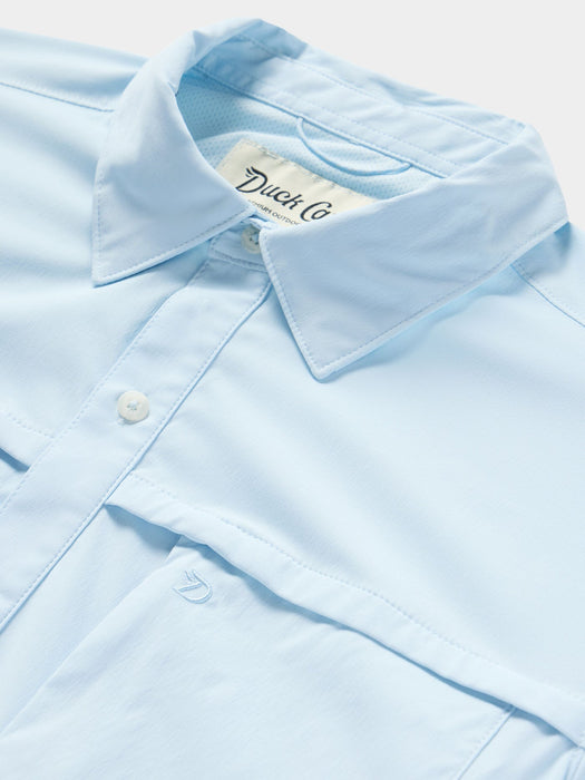 Close-up of the light blue Duck Camp short sleeve fishing shirt showing the collar buttons and premium nylon texture.