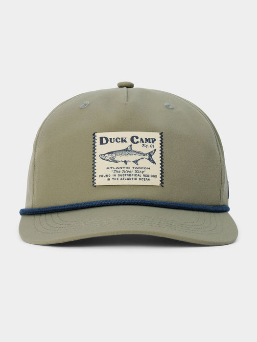 An olive green snapback cap with a blue rope detail along the brim and a central vintage-style patch reading 'Duck Camp' with a fish illustration, shown on a light gray background.