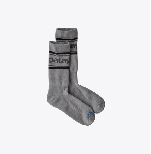 Pair of gray socks with black stripes and Patagonia branding on a white background