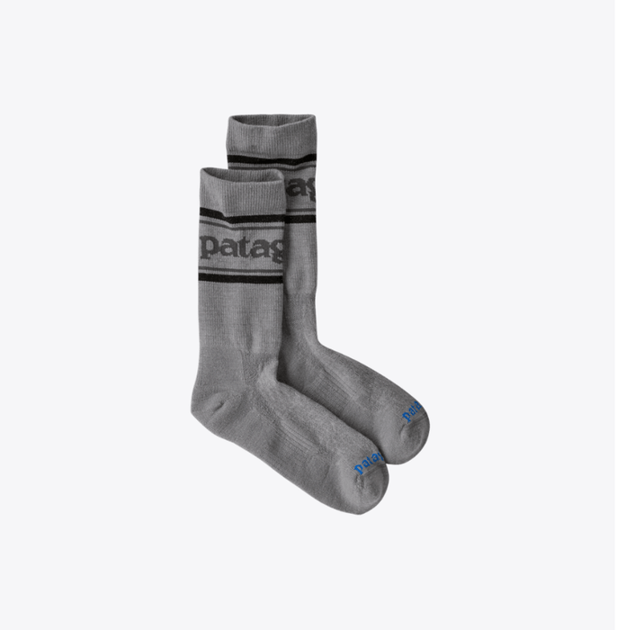 Pair of gray socks with black stripes and Patagonia branding on a white background
