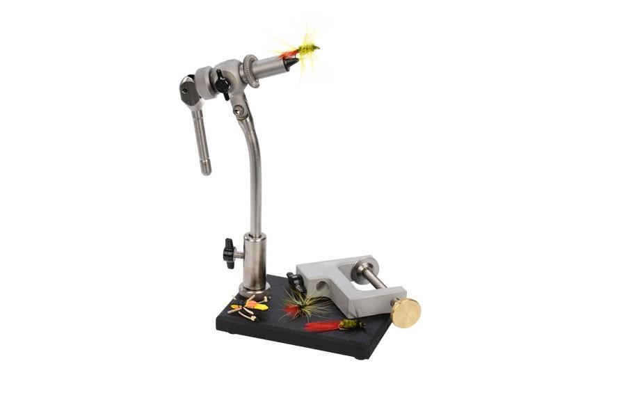 The Rambler Co. Apex Fly Tying Vise mounted on its heavy-duty black pedestal base, showcasing the stainless steel stem, adjustable c-clamp attachment, and a small yellow-winged fly clamped securely in the tool steel jaws.