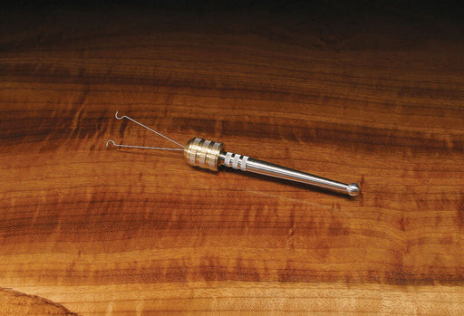 The Stonfo Rotodubbing #2 Split Twister tool featuring a knurled cylindrical silver handle, ball-bearing joint, and split wire loop prongs resting horizontally on a polished wood grain bench.