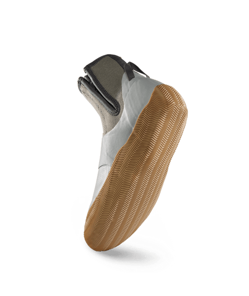 A single slip-on shoe shown from the side, featuring a light gray upper, a dark gray ankle collar, and a thick tan gum sole, isolated on a white background.