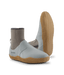 A pair of water shoes by Patagonia, featuring a white upper, a beige sock-like ankle collar, and a tan wavy-patterned sole, shown against a solid green background.