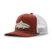 A corduroy trucker hat in rust red and white, featuring an embroidered shark patch on the front and a black-and-white stitched trim along the brim.