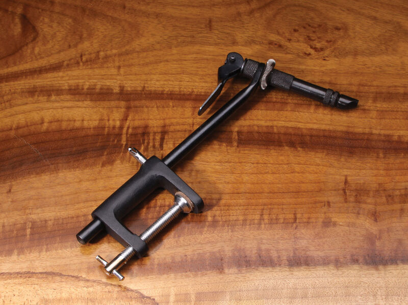 The Hareline Super AA Vise mounted on a polished wood surface, highlighting its black metallic stem, adjustable C-clamp base, lever-action tension mechanism, and heat-treated steel jaws.